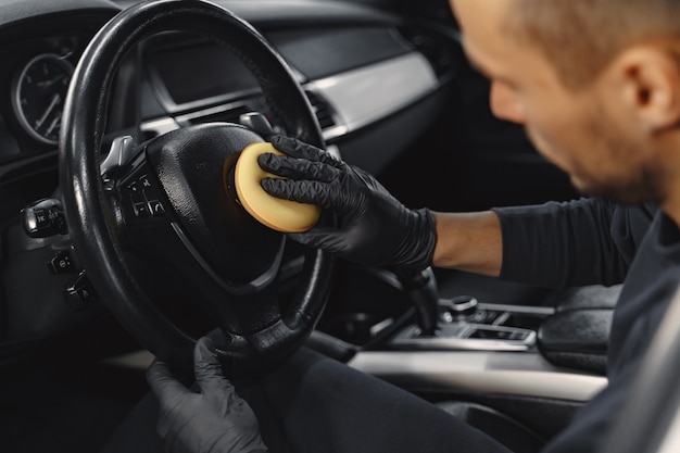 Man polish salon of car in a garage