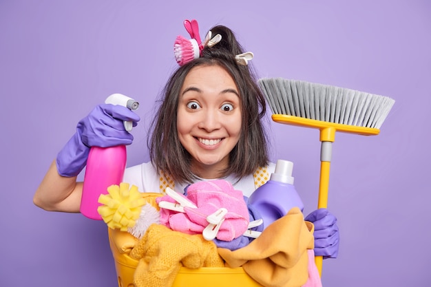 Free photo man poses with dispenser and broom supplies regular cleaning of house washes laundry uses chemical detergents poses indoor