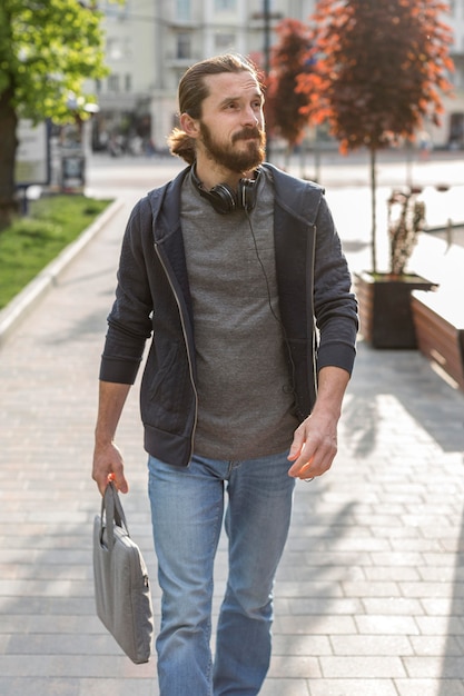 Man posing in the city while wearing headphones