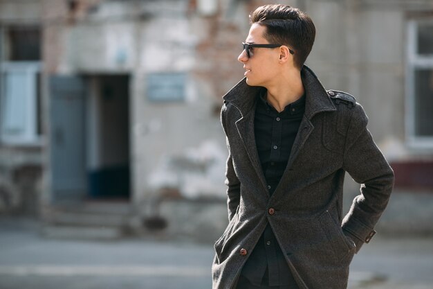 Man posing in raincoat and sunglasses