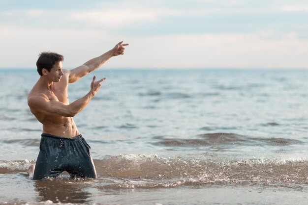 Man posing in water with copy space