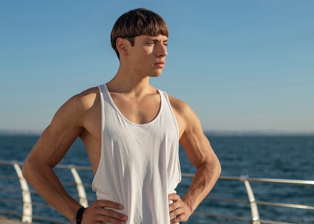 Man posing while exercising by the beach