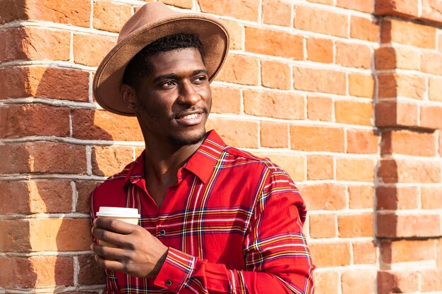 Man posing while holding a cup of coffee