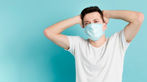 Man posing while wearing a medical mask with copy space