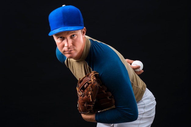 Man posing with baseball glove and ball