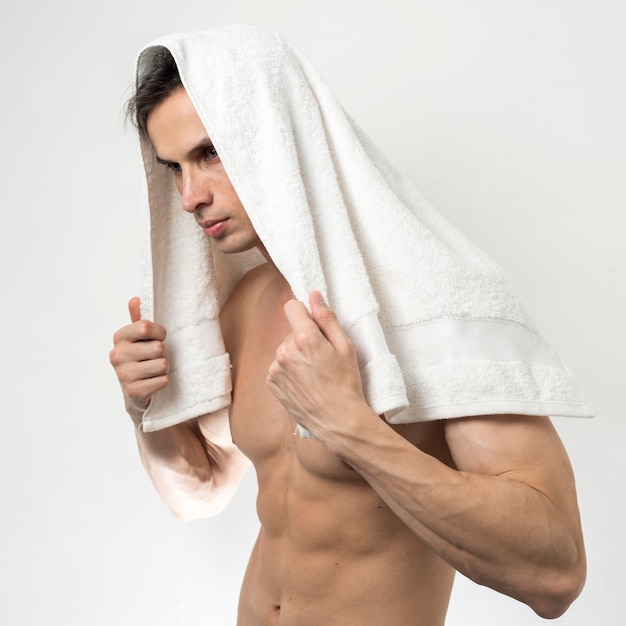 Free photo man posing with bathing towel on head