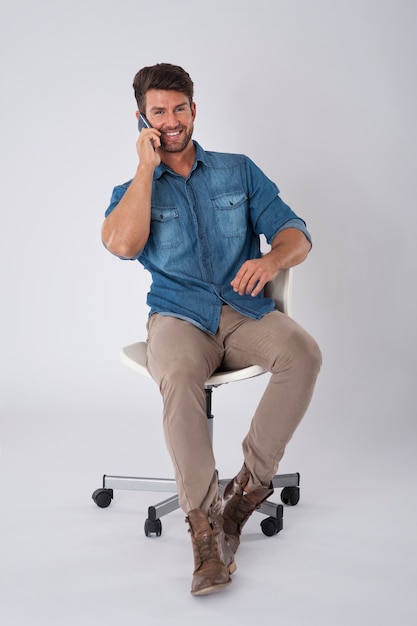 man posing with denim shirt sitting on a chair