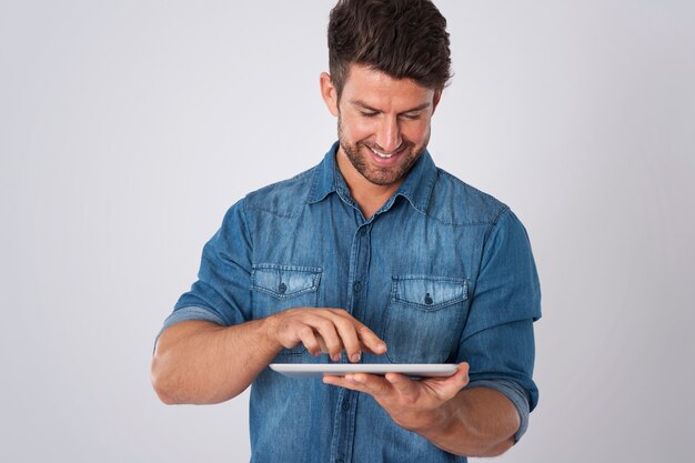 デニムシャツとタブレットでポーズをとる男