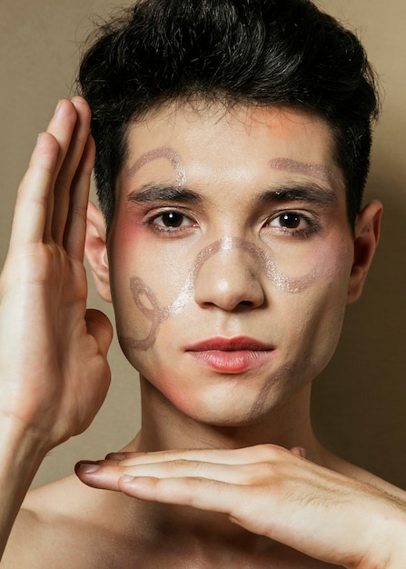 Man posing with hands and painted face