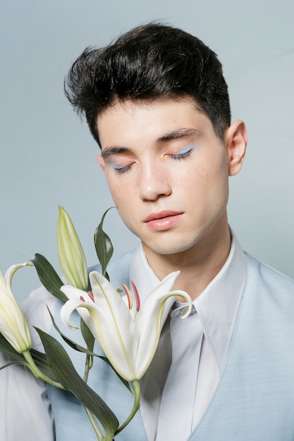 Man posing with lily and eyes closed