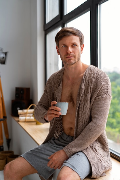 Free photo man posing with mug at home