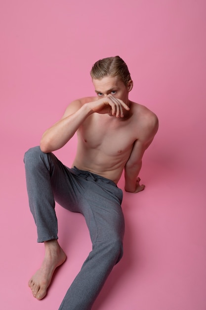 Бесплатное фото Мужчина позирует на розовом фоне под высоким углом