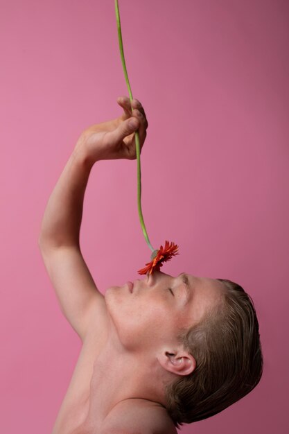 Man posing with red flower side view