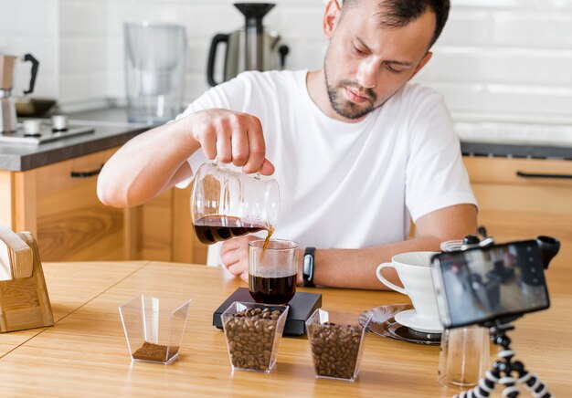 カップにコーヒーを注ぐ男