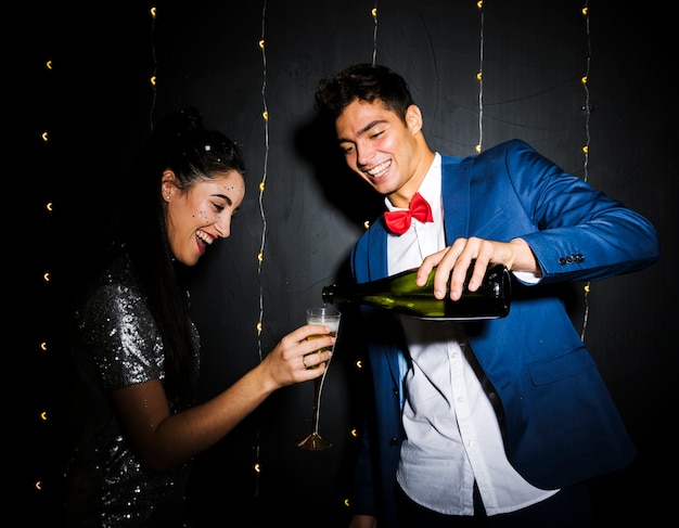 Free photo man pouring drink in glass of smiling young woman