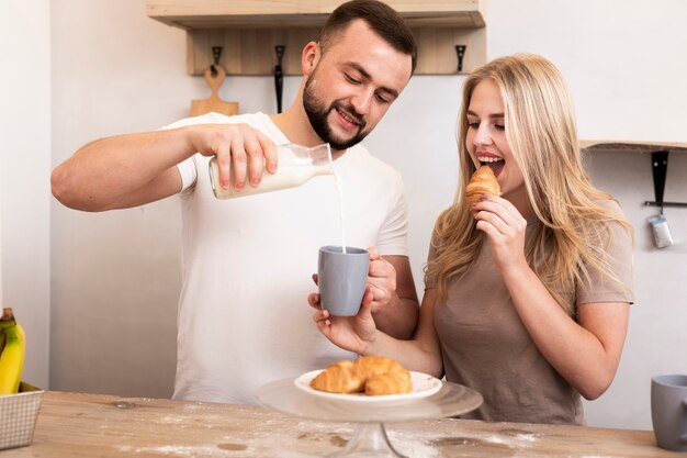 カップに牛乳を注ぐ男