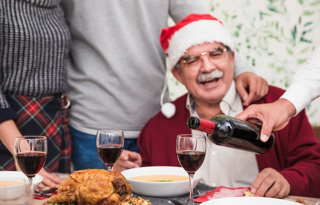 Бесплатное фото Человек, наливая красное вино в стакане на праздничный стол