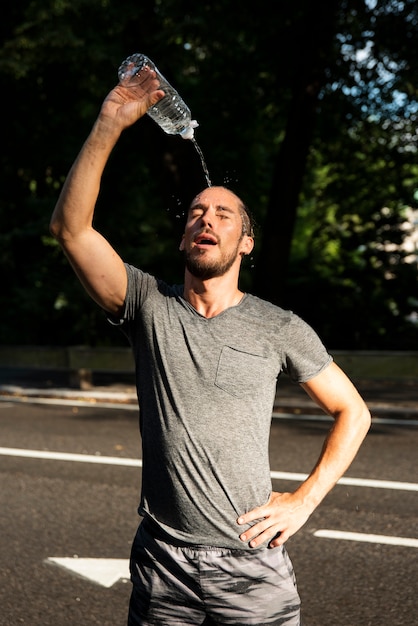 Man pouring water over his head