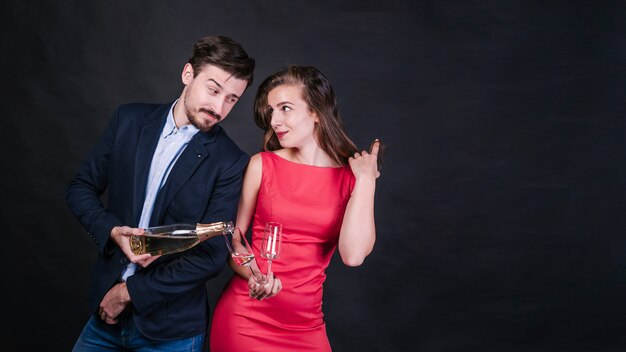 Man pouring wine in glass of woman