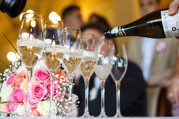 Man pours champagne in the glasses 