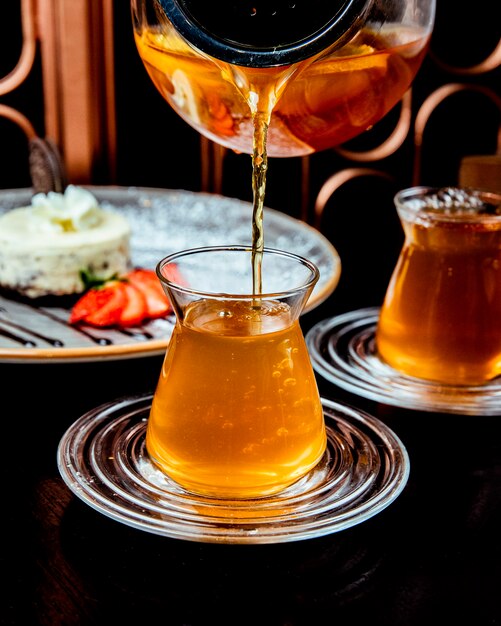 Man pours citrus tea in the glass side view