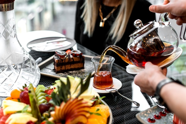 Free photo man pours tea into the armudu glass