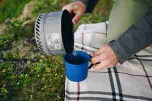 Free photo man pours water from gas camping stove