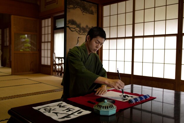 Человек, практикующий японский почерк кистью и чернилами