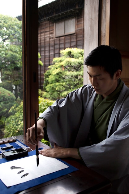 筆で日本の手書きを練習する男