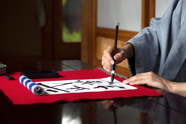 Man practicing japanese handwriting with a brush