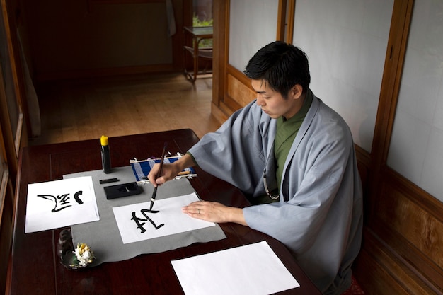 Free photo man practicing japanese handwriting