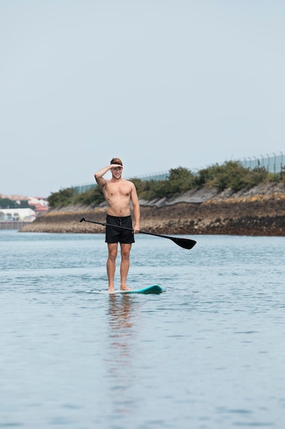 Free photo man practicing paddle surf