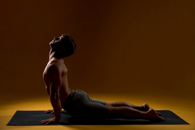 Free photo man practicing yoga pose