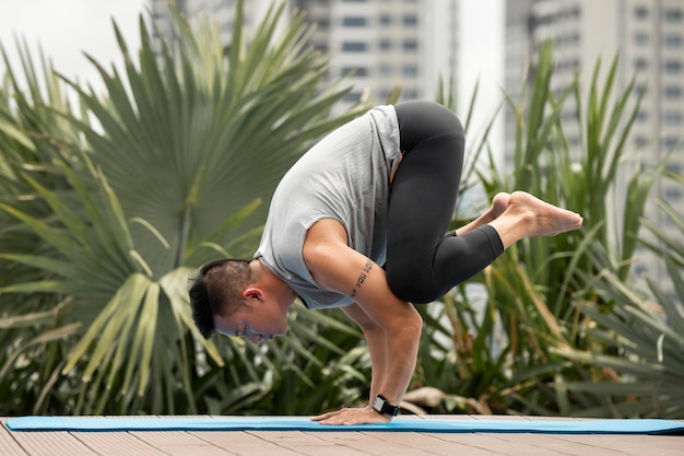 Free photo man practicing yoga position outside