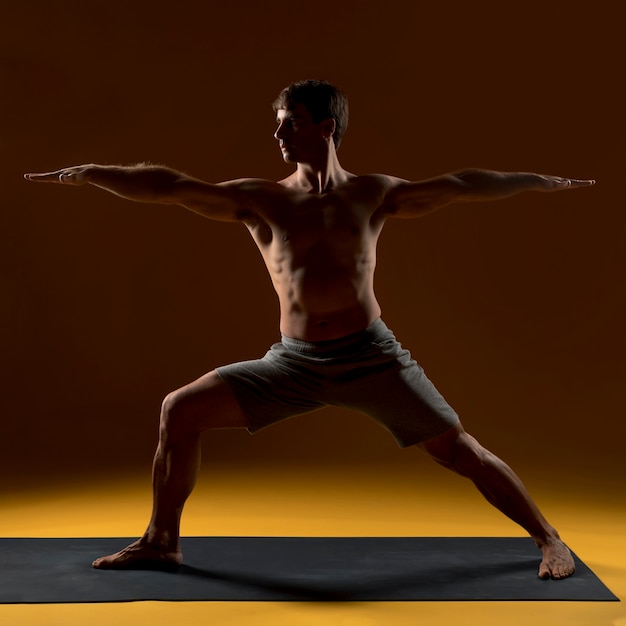 Man practicing yoga positions on mat