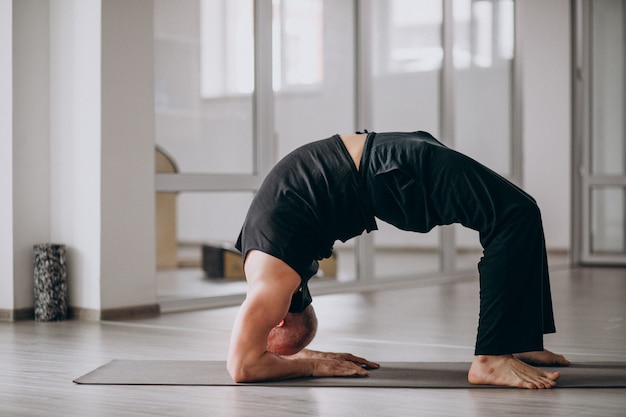 Man practising yoga in the gym