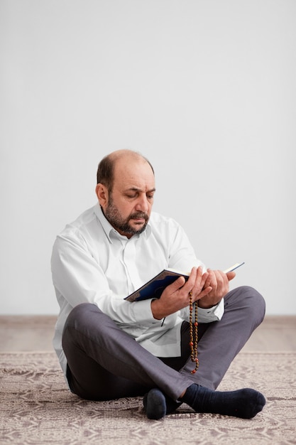 Foto gratuita uomo che prega sul pavimento al chiuso