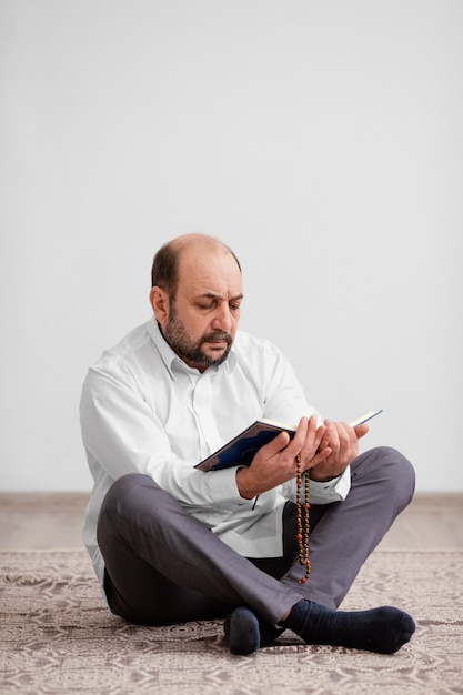 Free photo man praying on the floor indoors