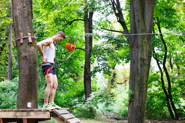 男は公園のロープに登る準備をする