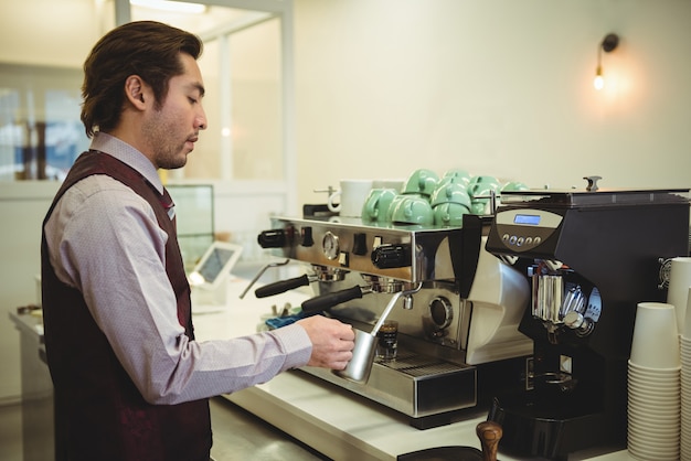 Free photo man preparing coffee in coffee machine