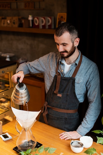 Free photo man preparing coffee for coffee shop