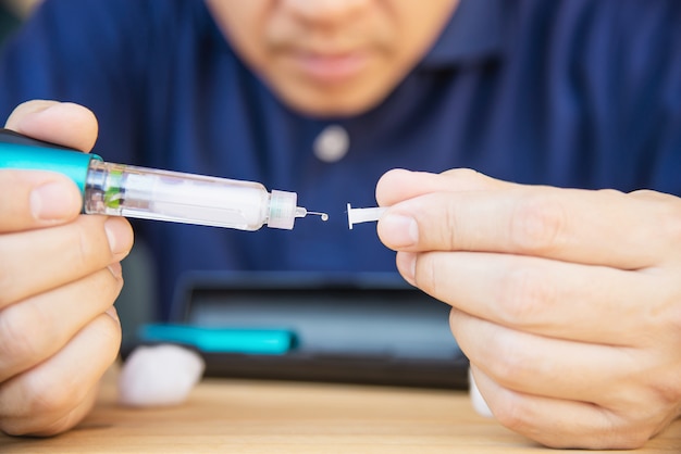 Man preparing insulin diabetic syringe for injection