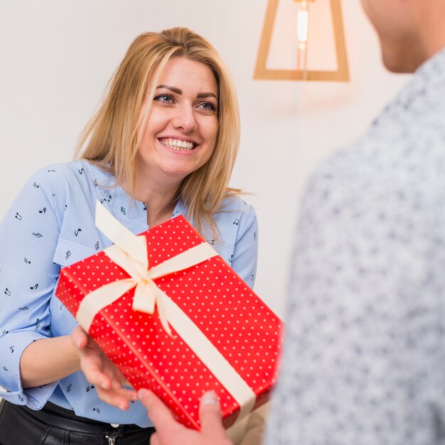 Man presenting gift box to happy woman 