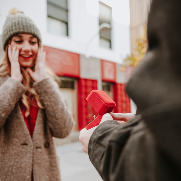 Man proposing to surprised woman