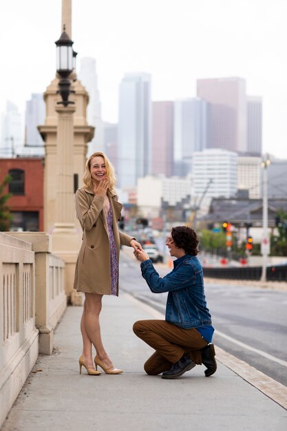 通りで屋外の女性にプロポーズする男性