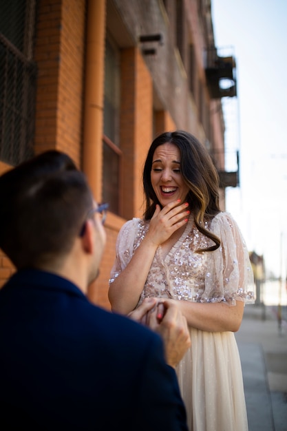 Man proposing to woman with engagement ring in the city