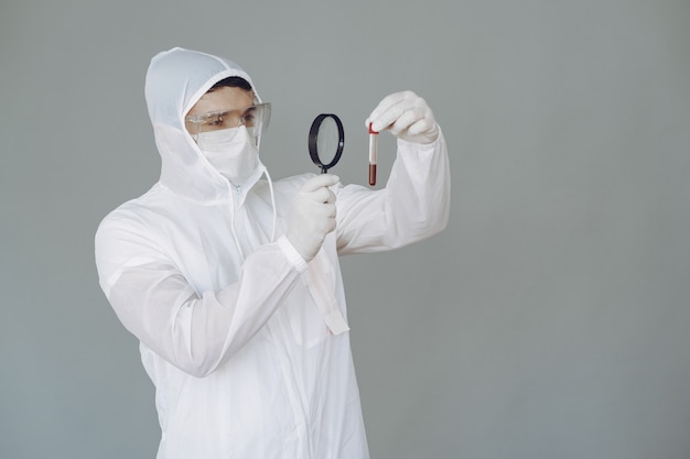 Free photo man in protective suit and glasses on grey wall