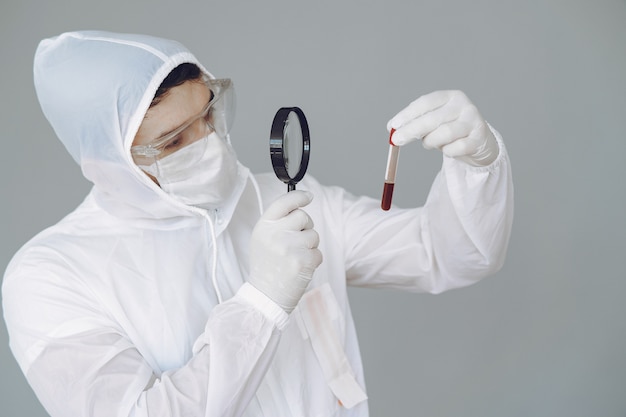 Man in protective suit and glasses on grey wall