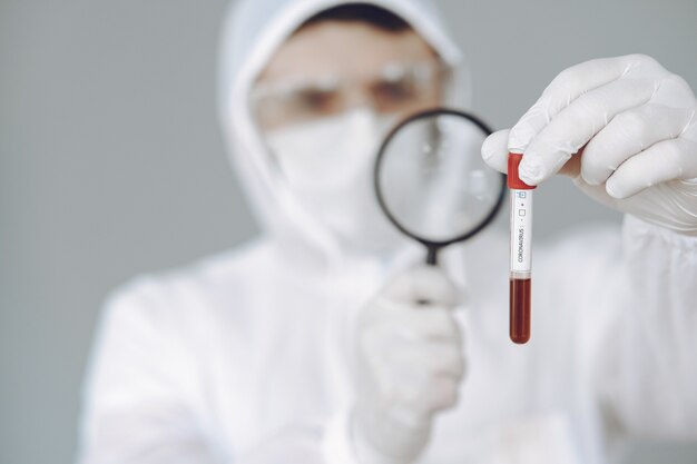 Man in protective suit and glasses on grey wall