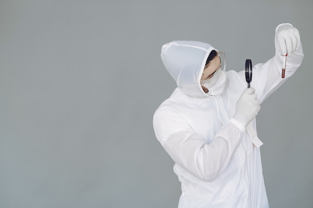 Man in protective suit and glasses on grey wall